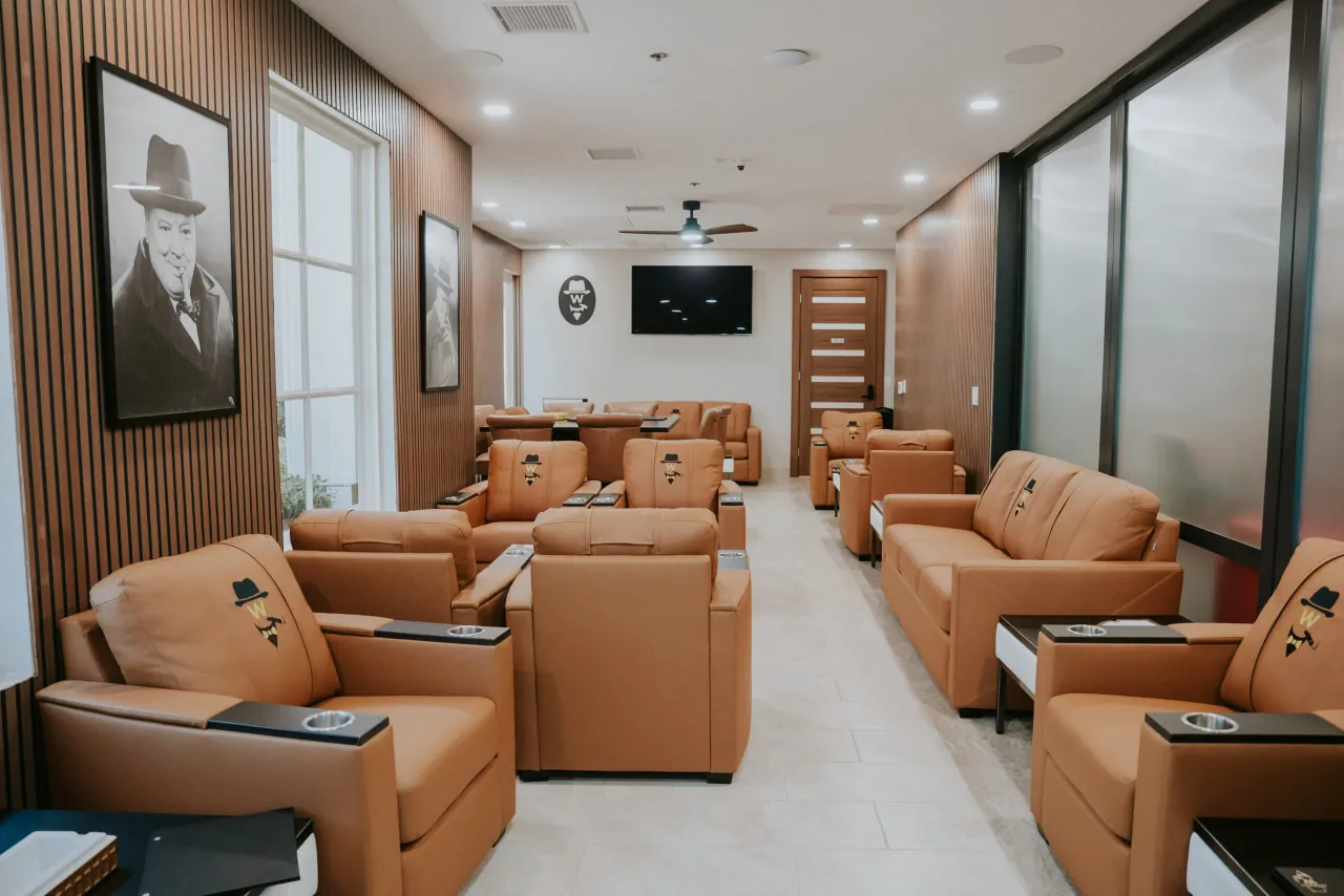 The Churchill Room: tan leather recliners with the Winston's mark, slatted wood walls and portraits of Churchill