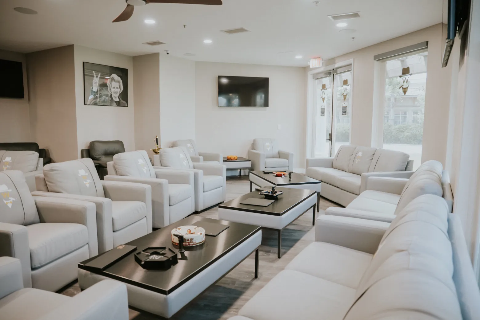 The lounge at The Winston's Club: white leather club chairs and sofas around dark wood tables